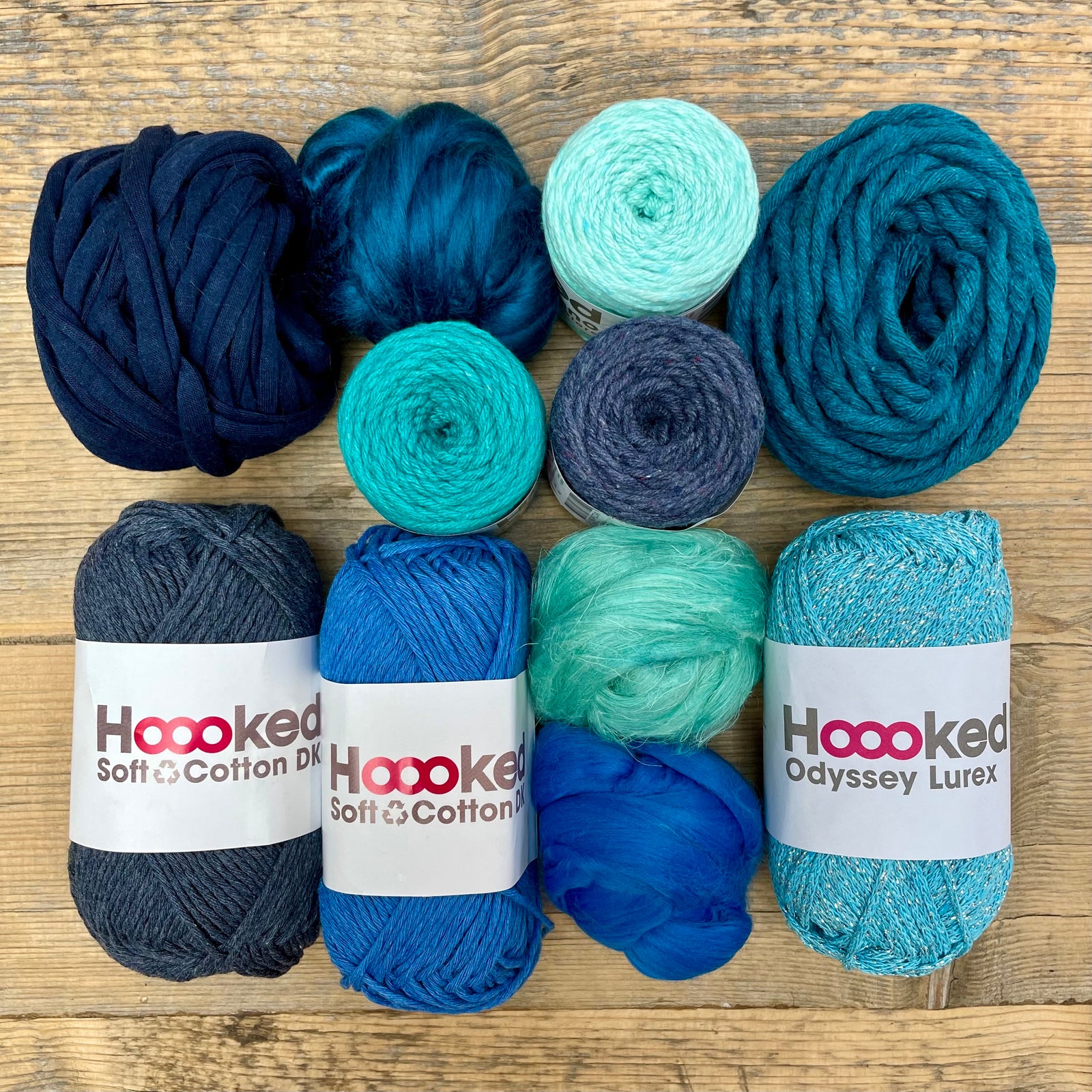 A multi-coloured yarn pack is displayed with an assortment of weaving yarn and fibre suitable as tapestry yarn, craft yarn, fiber art yarn and more. The colour way for these weaving supplies is 'Marine'.